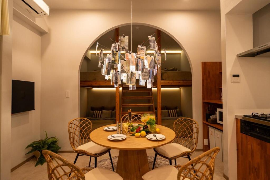 a dining room with a table with chairs and a chandelier at SUNZ ROOMS -naha miebashi- in Naha