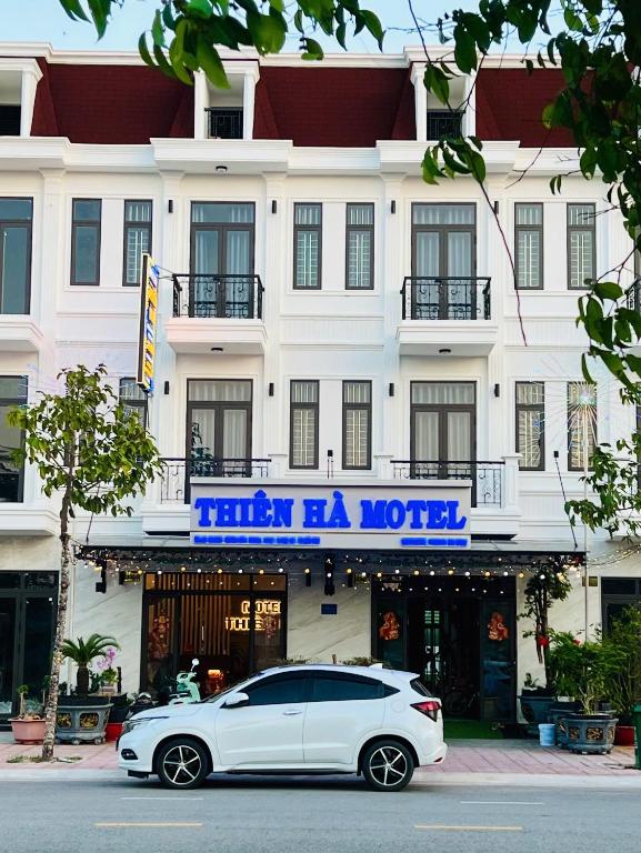 a white car parked in front of a hotel at THIÊN HÀ Motel in Soc Trang