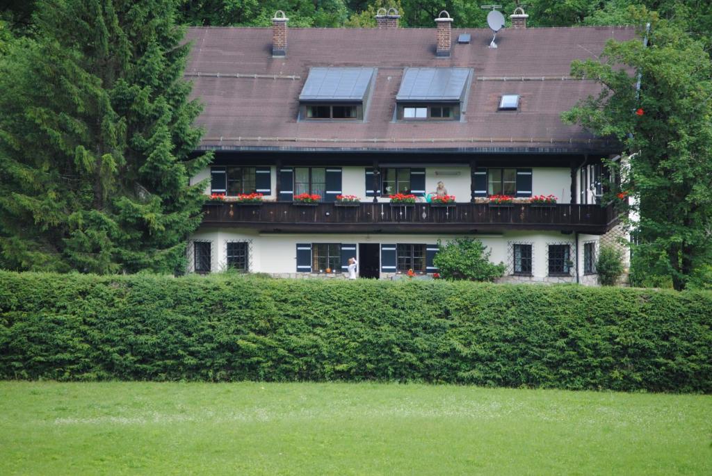 a large house with a balcony with flowers on it at Ferienwohnung Alpenvilla in Bischofswiesen