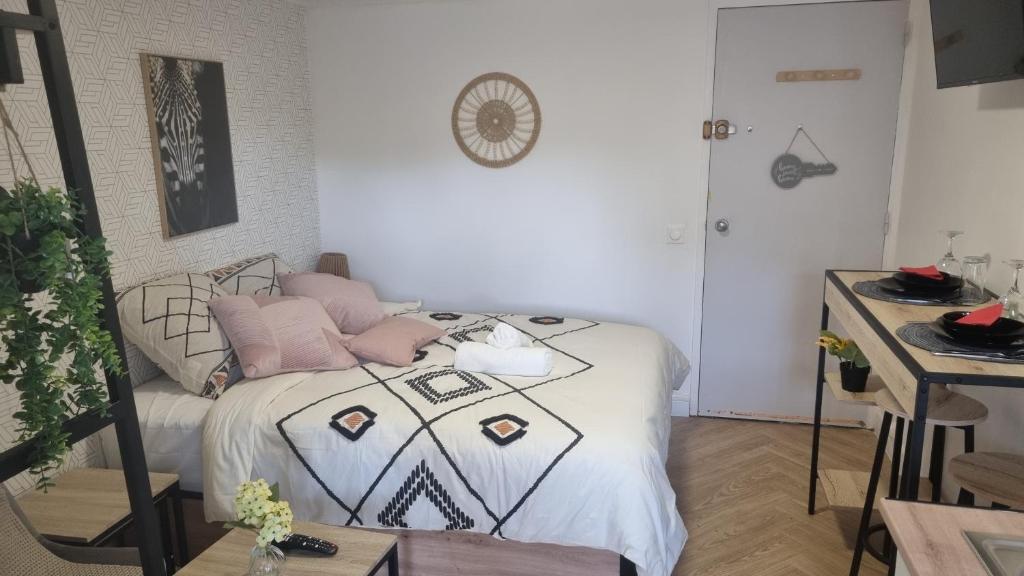 a bedroom with a bed with pink pillows on it at Golden Cottage Stade P Mauroy Lille in Villeneuve d'Ascq