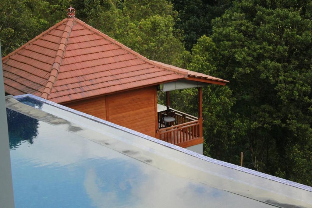 a small house with a roof next to a swimming pool at STHANATAPA HILL's in Sidemen
