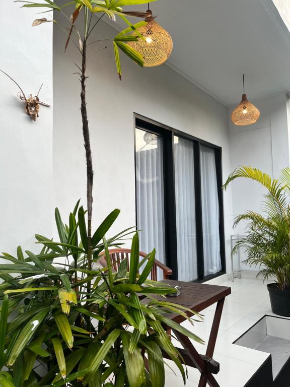 a dining room with plants and a wooden table at JS Guest House in Seminyak