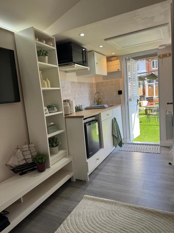 a kitchen with white cabinets and a door to a yard at Maple Gem in Birmingham