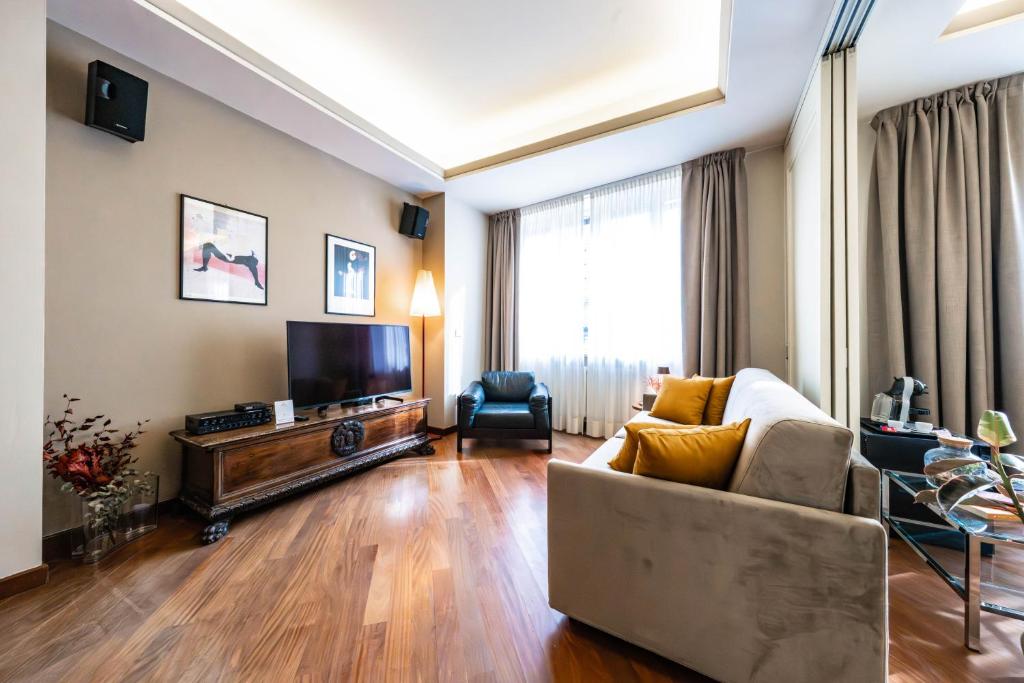 a living room with a couch and a television at Cavour Suite Luxury in Bologna