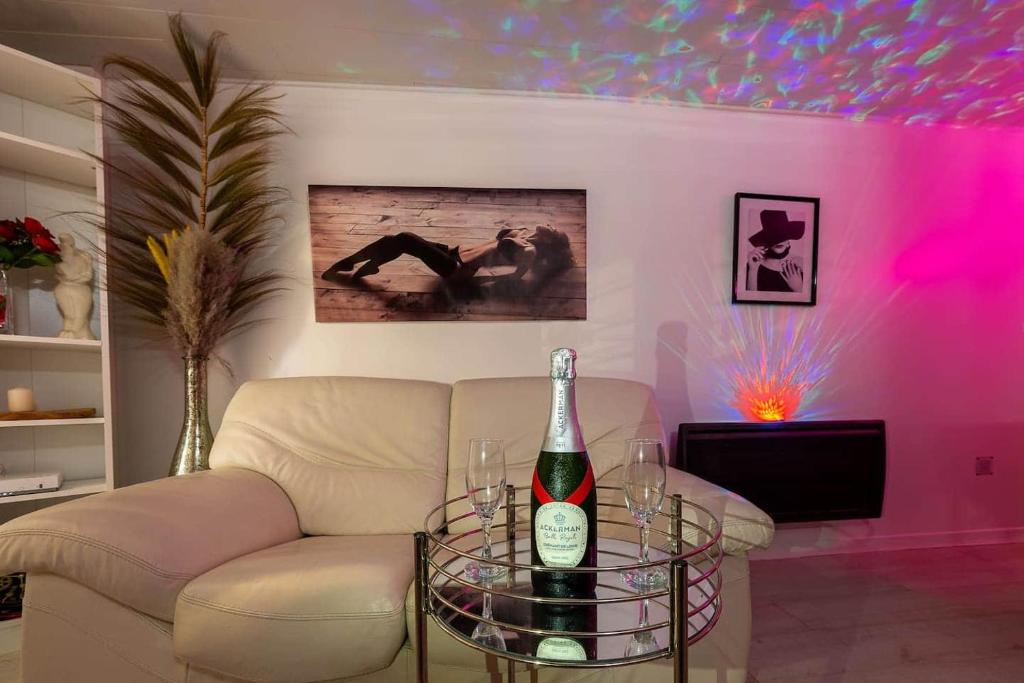 a living room with a couch and a bottle of wine at love escape "Love Room" in Saint-Paul-Trois-Châteaux