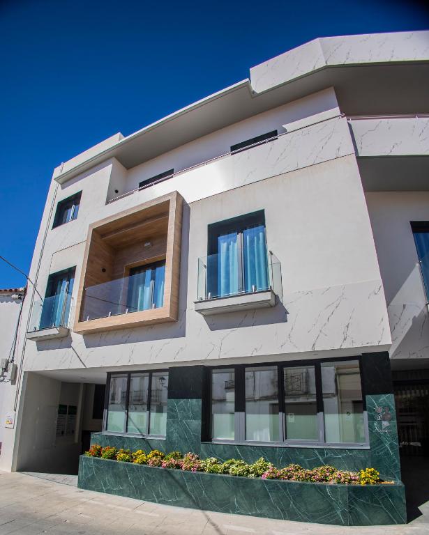 a large white building with windows and a balcony at OIKOS APARTAMENTOS TURÍSTICOS in Monesterio