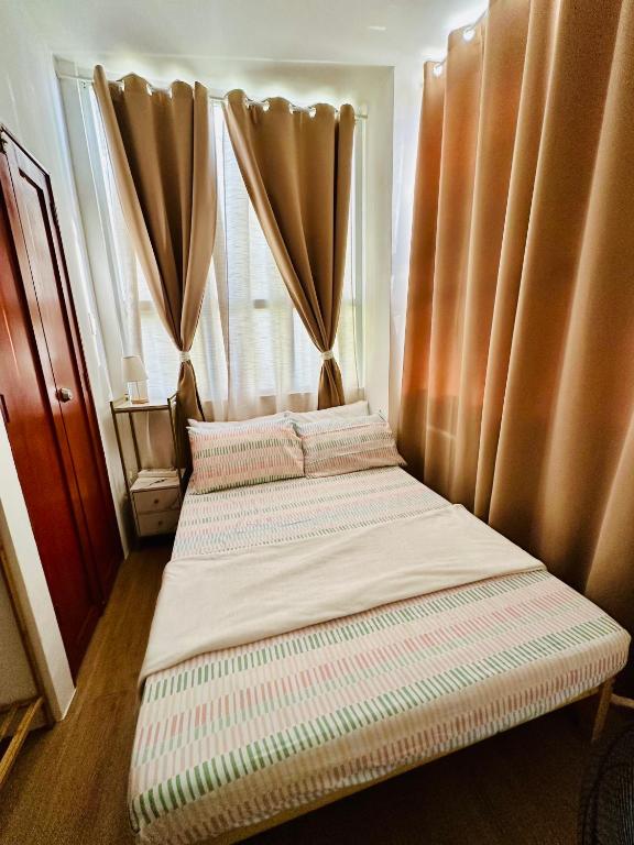 a bedroom with two beds in front of curtains at Bayanihan Flats 2 in Pajak