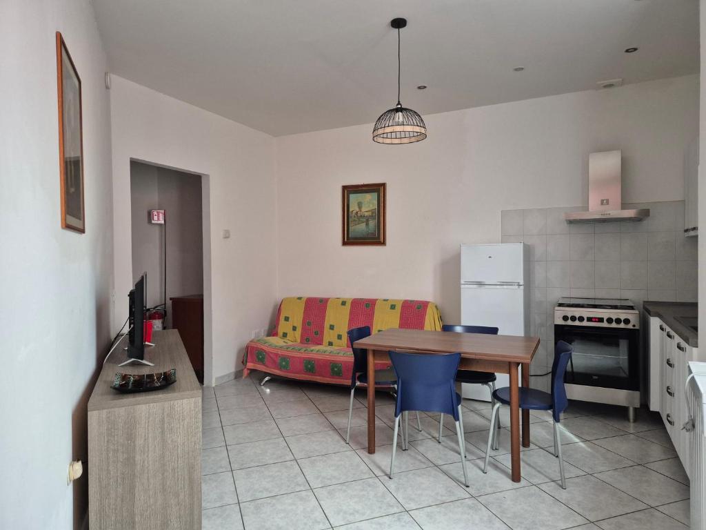 a kitchen with a table and a living room with a couch at Accogliente appartamento Fucecchio in Fucecchio
