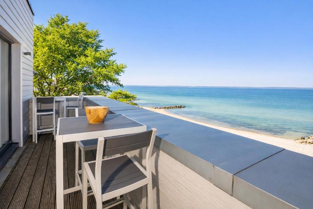 a table and chairs on a balcony overlooking the beach at Ostsee Suite 1 - Strandperle in Niendorf