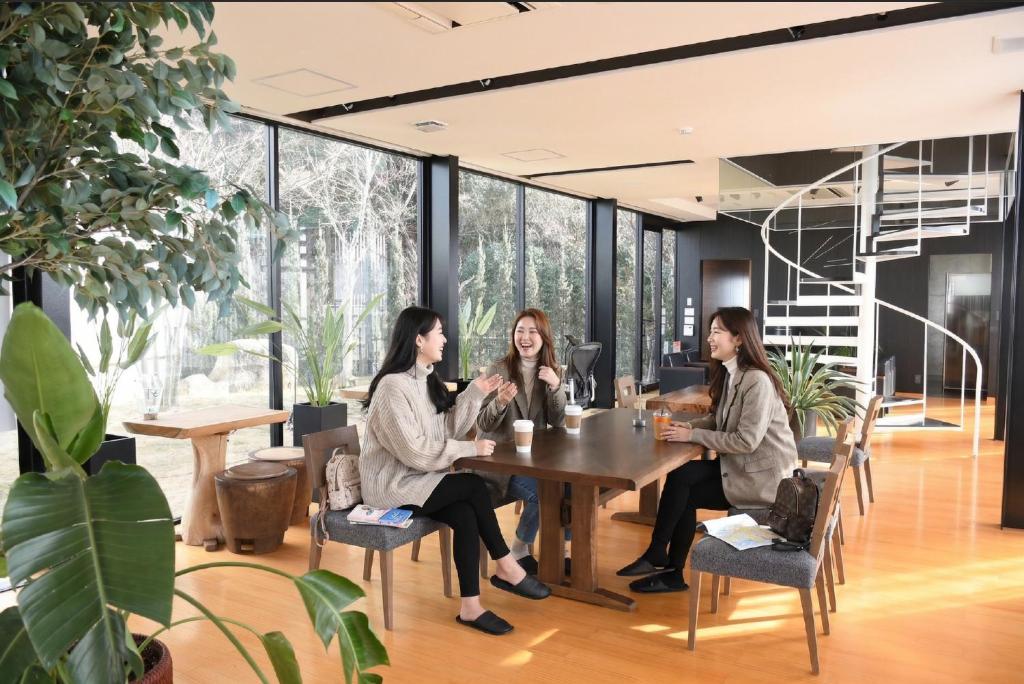 three women sitting at a table in an office at SENJA Dewata in Mitoyo