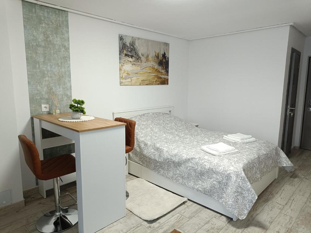 ein weißes Schlafzimmer mit Bett und Schreibtisch in der Unterkunft Harmony Studio in Târgu Secuiesc