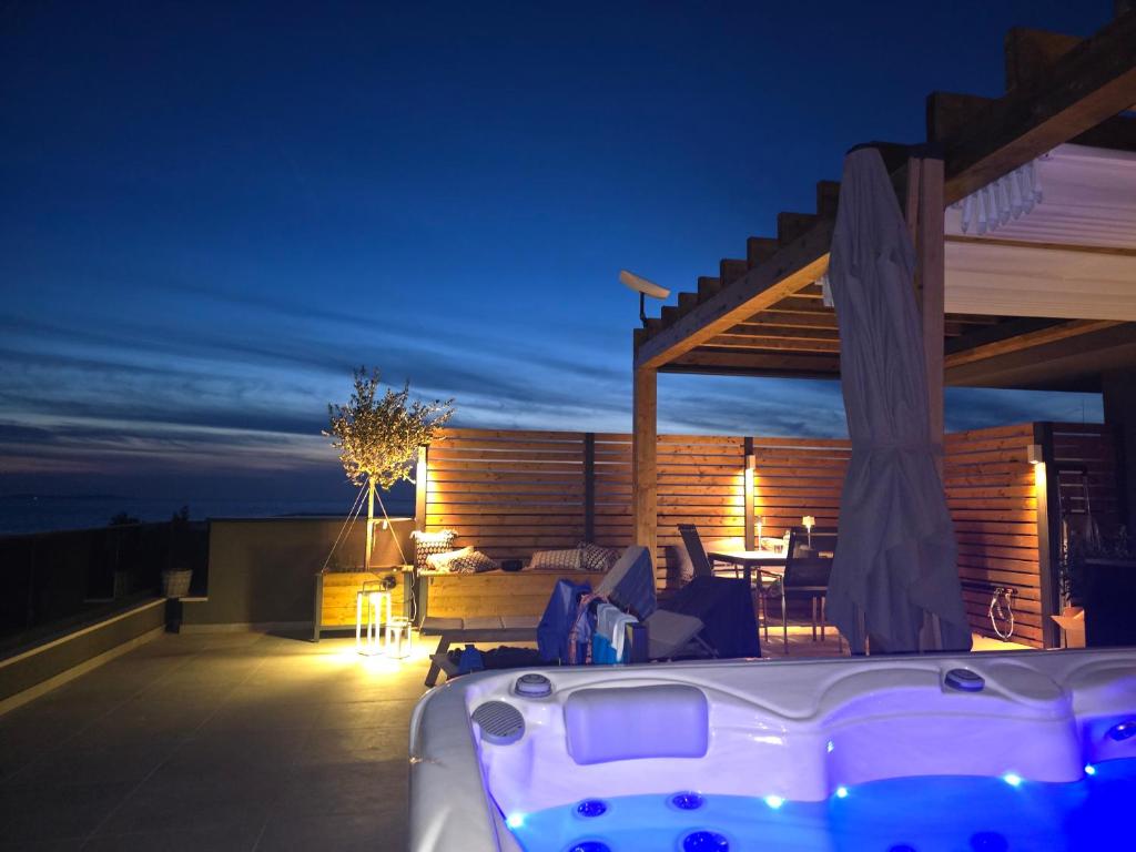 a hot tub on the roof of a house at night at Starview in Privlaka