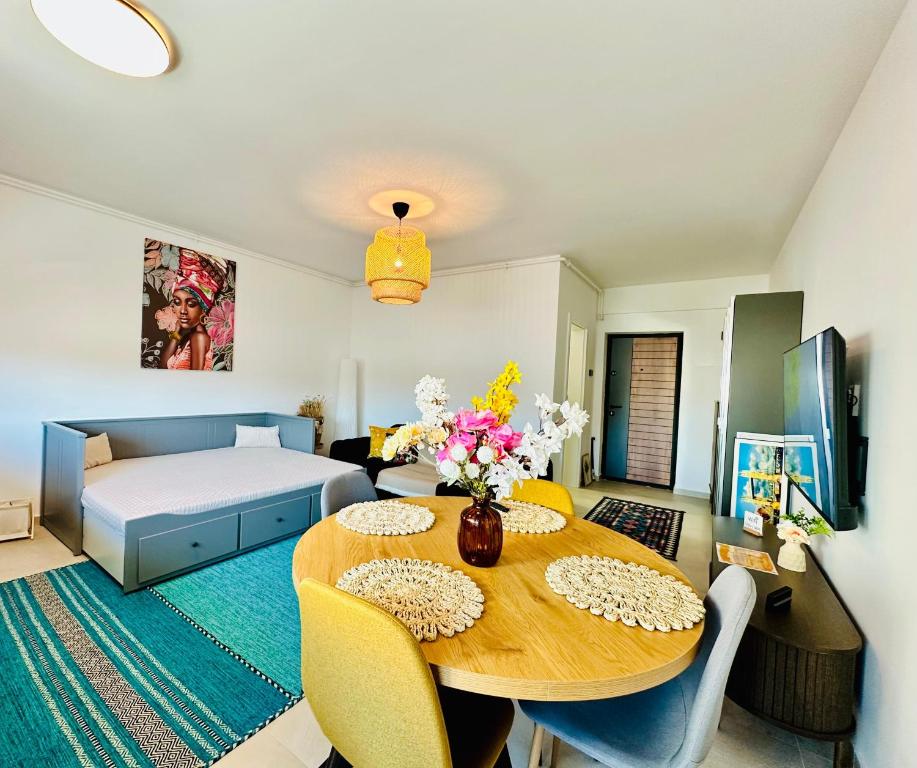 a living room with a table and a bed at Caro Studio in Tunari