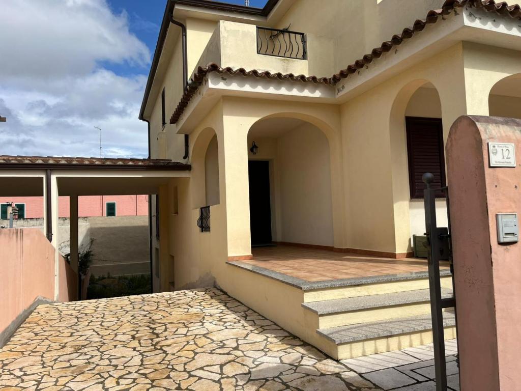 a building with a gate and steps to a house at Casa FLORE in Orosei