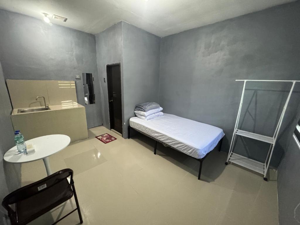 a small room with a bed and a table at Evas Inn in General Santos