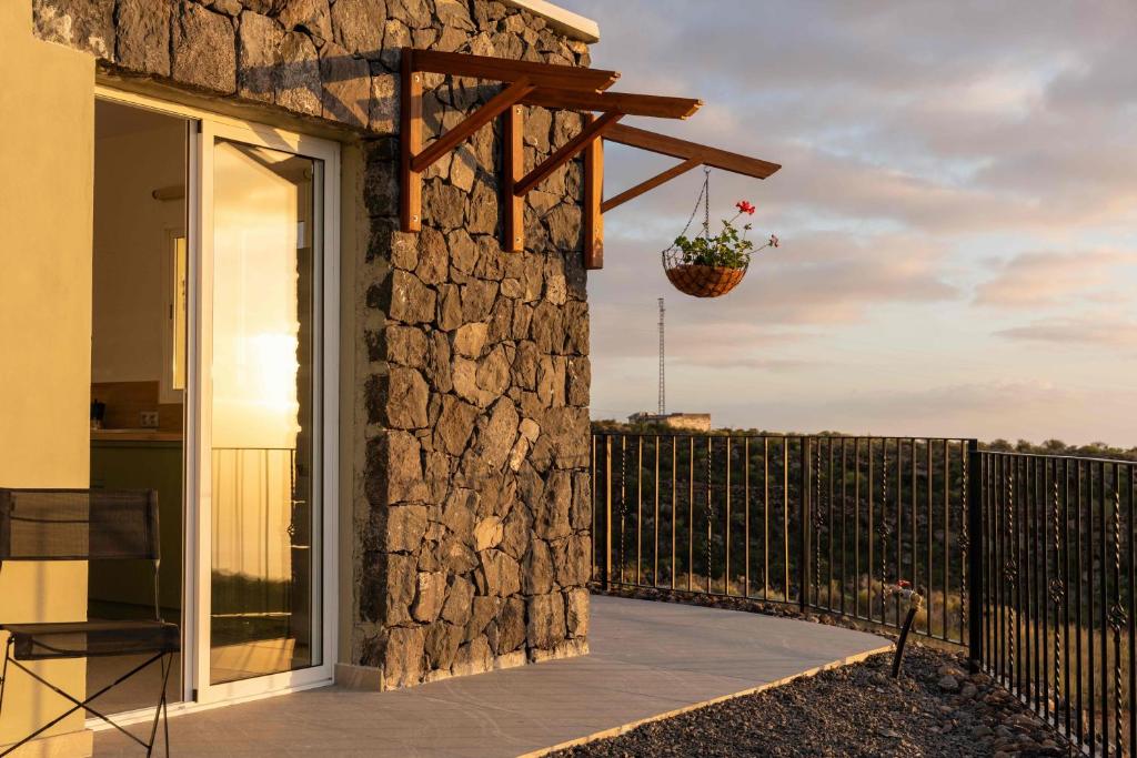 a balcony with a stone wall and a potted plant at Finca el Vinche in Guía de Isora