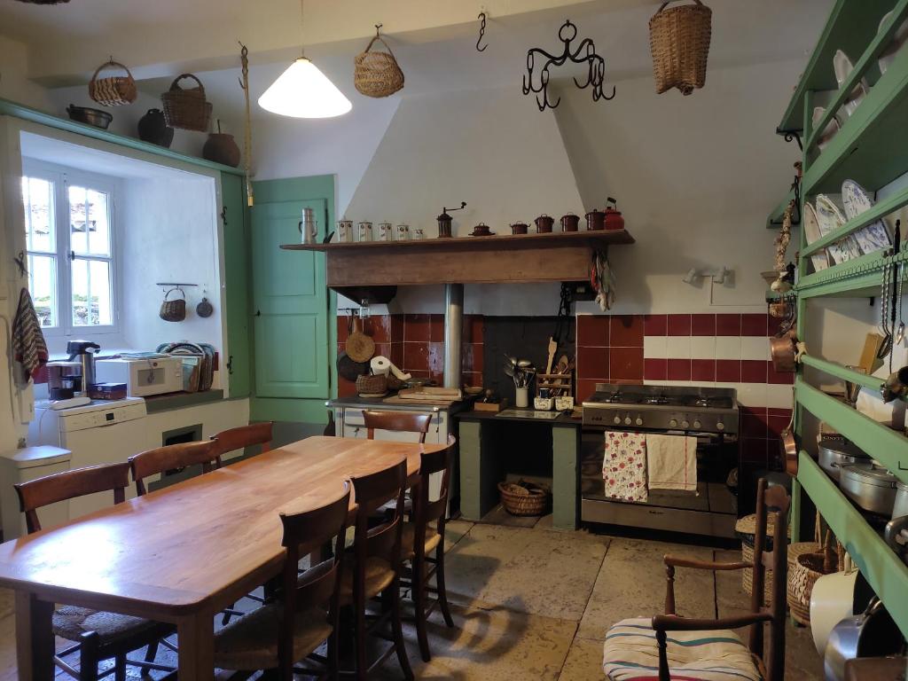 a kitchen with a wooden table and a stove at Maison Emile Teissier in Vébron