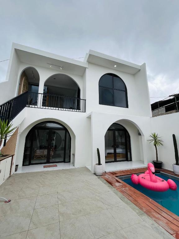 a large white house with a swimming pool at Villa Suarga Loka in Tutugan