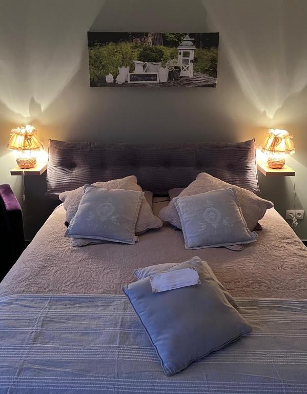 a bed with two pillows on it with two lamps at la ferme au bois dormant in Wemaers-Cappel