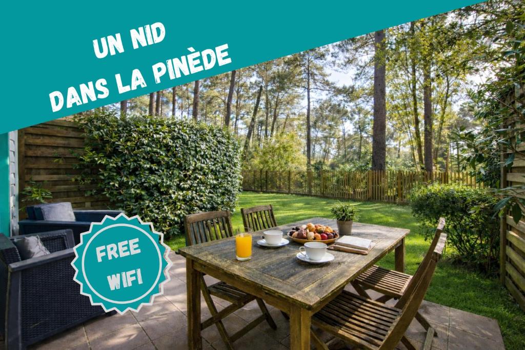 a wooden table with a bowl of fruit on a patio at Maison 2 chambres 6 pers à Lacanau Océan, piscine, golf, Wi-Fi in Lacanau