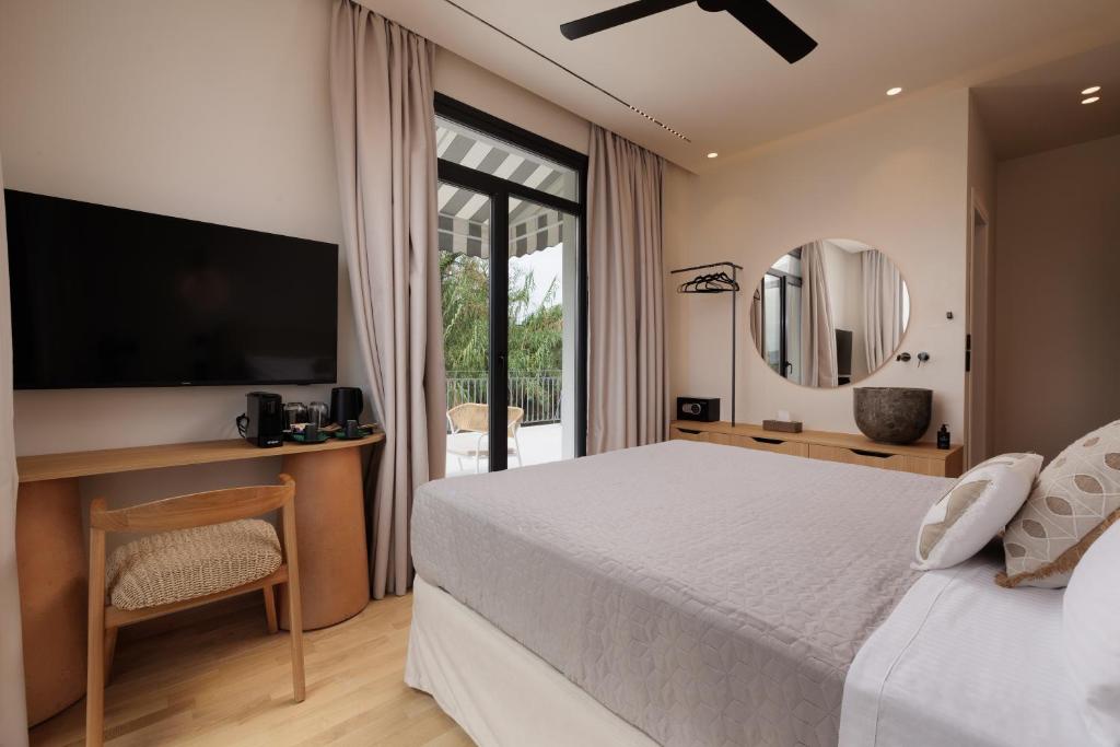 a bedroom with a bed and a desk and a television at Avia in Corfu