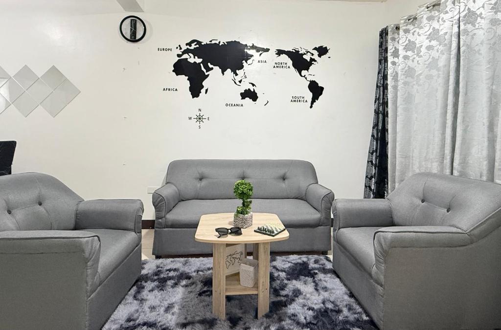 ein Wohnzimmer mit zwei Sofas und einer Weltkarte an der Wand in der Unterkunft Sakura Crib at Xevera Calapan in Camilmil