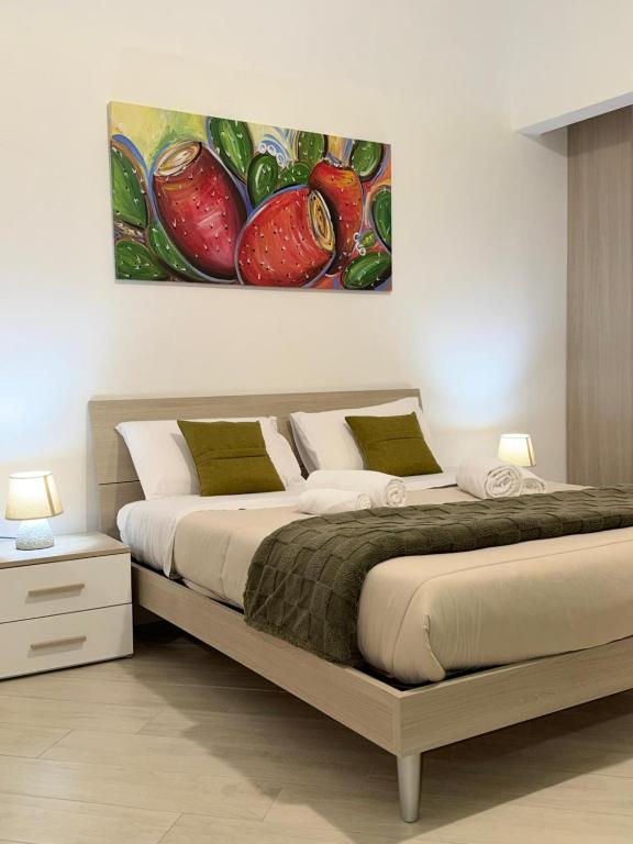 a bedroom with a bed with a painting on the wall at Trinacria Rooms 1 in Carini