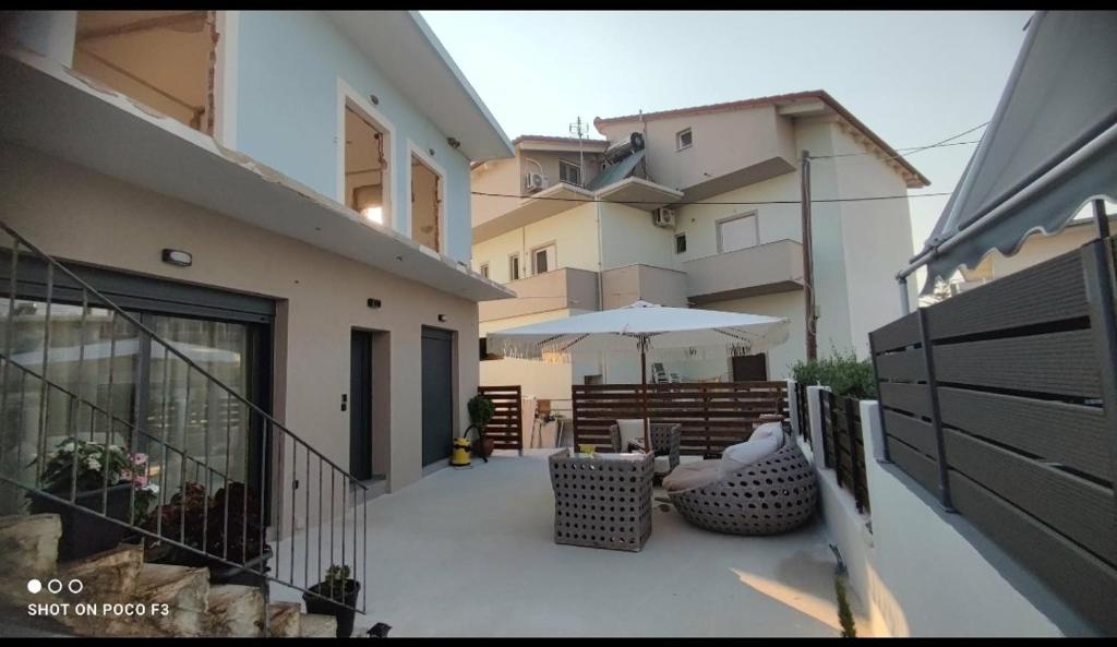 a balcony with a table and an umbrella at KANALI HOLIDAYS APARTMENT 5 in Preveza