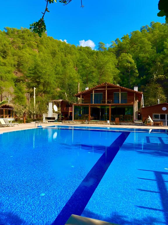 a large swimming pool in front of a house at Gizli Cennet Villages Hotel in Fethiye