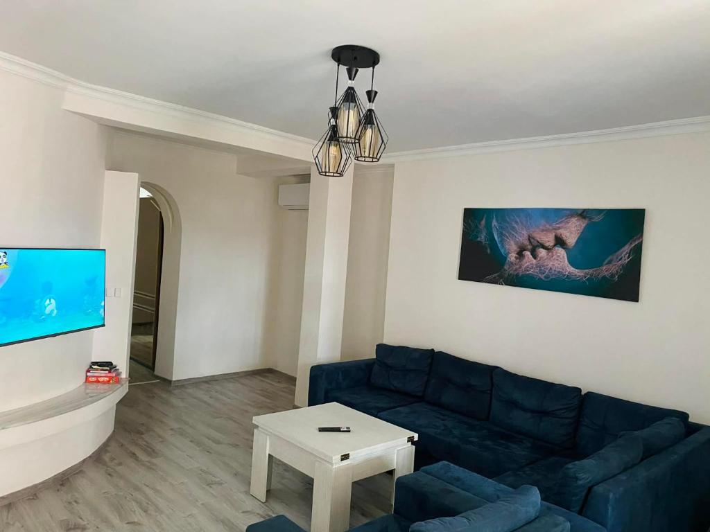a living room with a blue couch and a tv at Welcome2 in Kobuleti