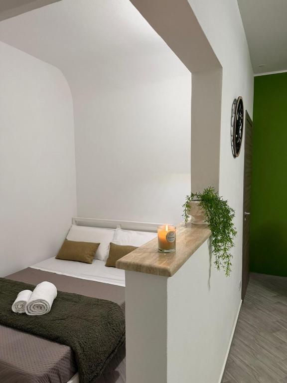 a small bedroom with a bed and a table with a candle at Casa Verdi in Carini