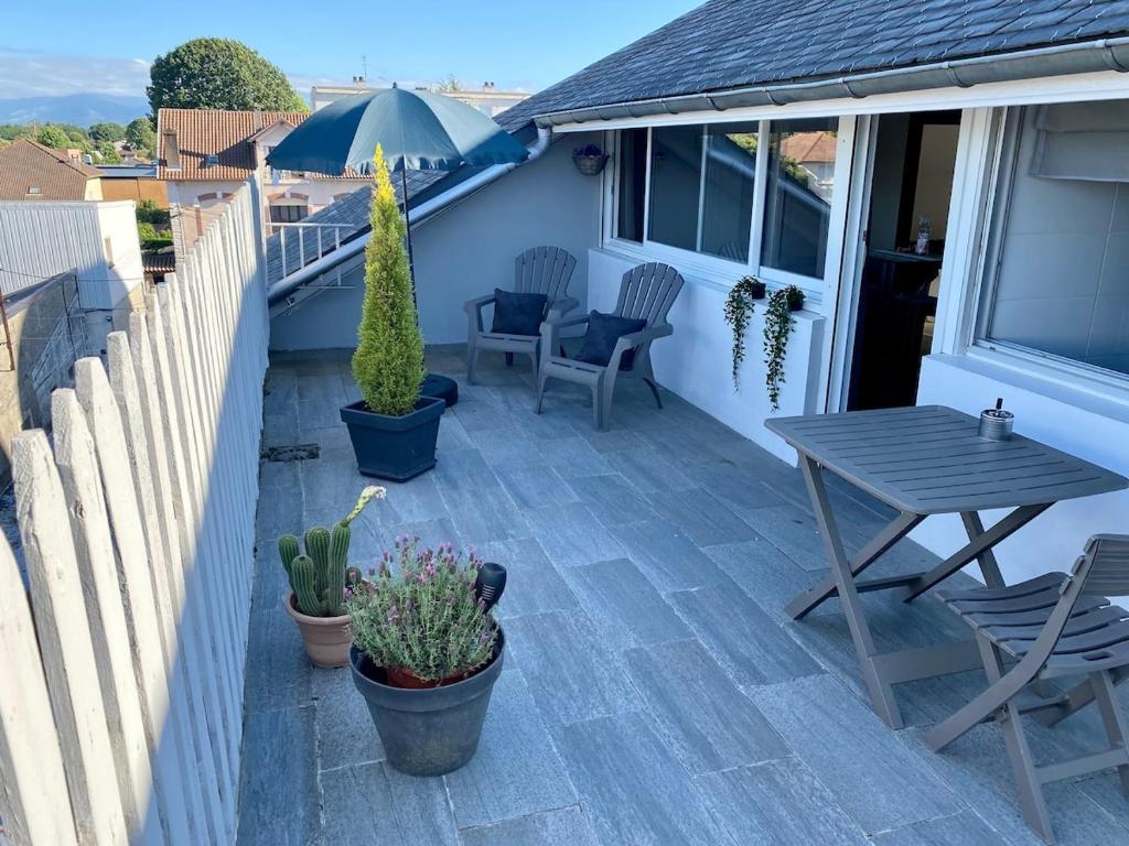 a patio with a table and chairs and an umbrella at Private studio in Loft in Tarbes in Tarbes