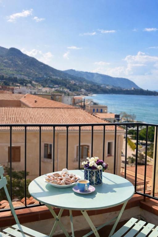 a table with a plate of food on a balcony at Spinuzza Boutique Guesthouse Cefalù, Sicily in Cefalù