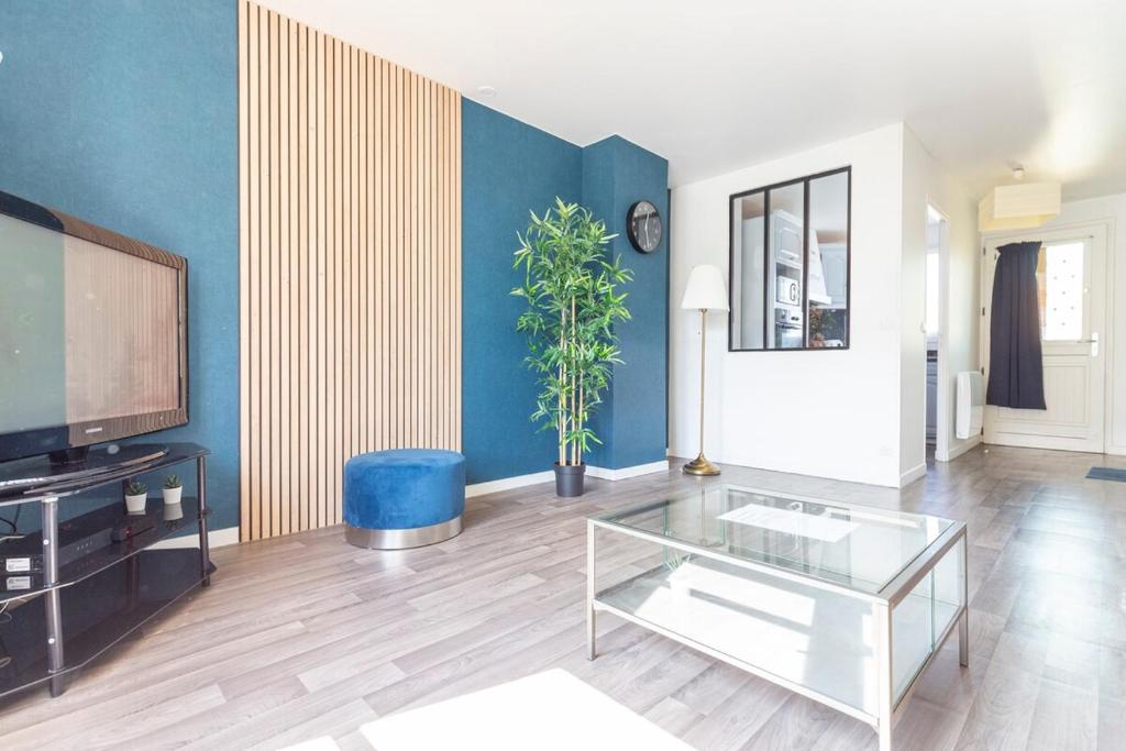 a living room with a tv and a glass table at Exceptional duplex at Disneyland Paris in Serris