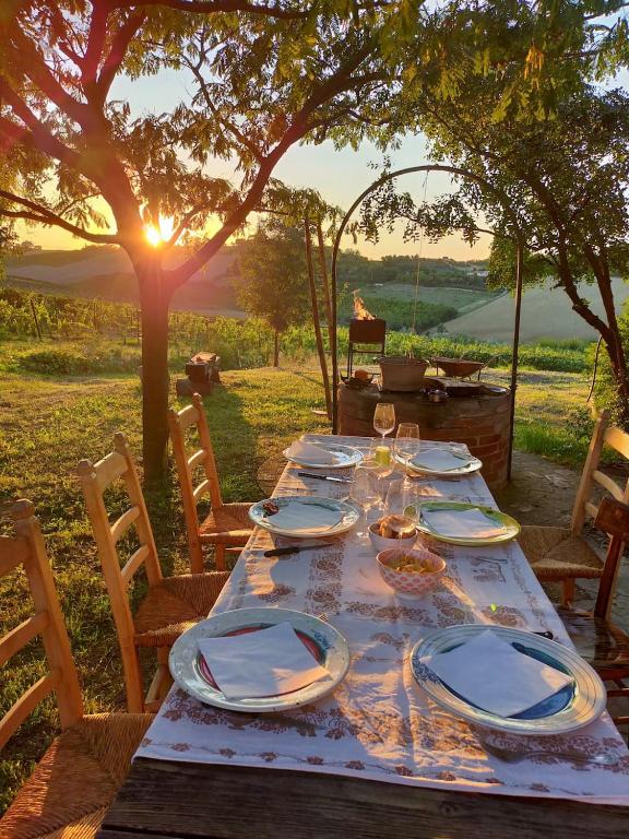 a wooden table with plates and wine glasses on it at Casa Quadrilumi B&B in Imola