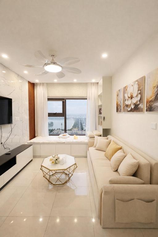 a white living room with a couch and a tv at Luxury 1BR Apartment - Ocean Lake View - Vinhomes Ocean Park in Gia Lâm Pho