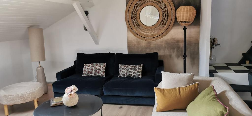 a living room with a blue couch and a table at Chez Ariel et Myrtille in Bruyères