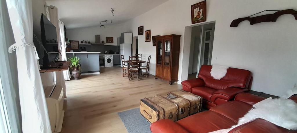a living room with a red couch and a table at Haut de villa calme, 2 chambres et vue dégagée - proche calanques in Roquefort-la-Bédoule