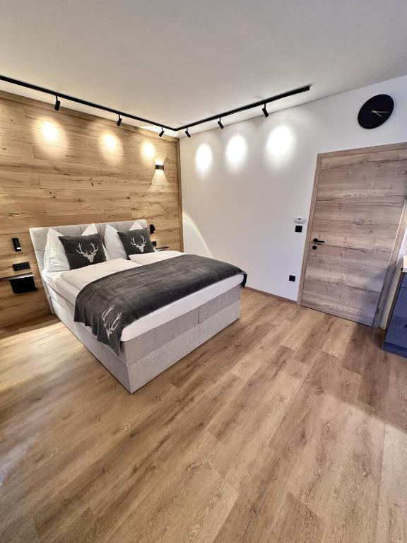 a bedroom with a large bed and a wooden wall at Alpin Studio Haus, Kaibling & Ski amadé in Haus im Ennstal