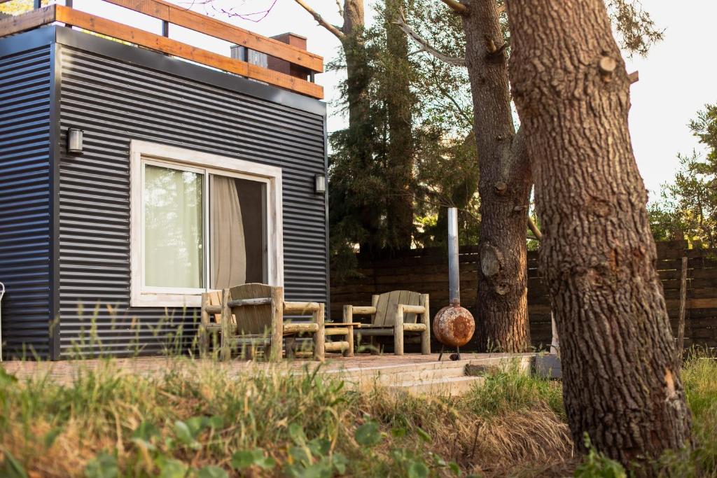 a cabin with chairs and a table next to a tree at Diez Pinos in Punta del Este