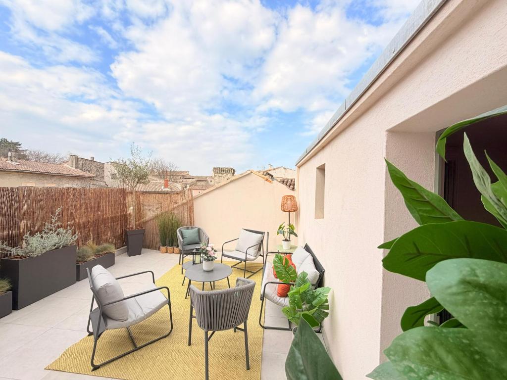 a patio with chairs and a table and some plants at Maison familiale rénovée avec terrasse, 4 chambres, proche L'Isle-sur-la-Sorgue in Pernes-les-Fontaines