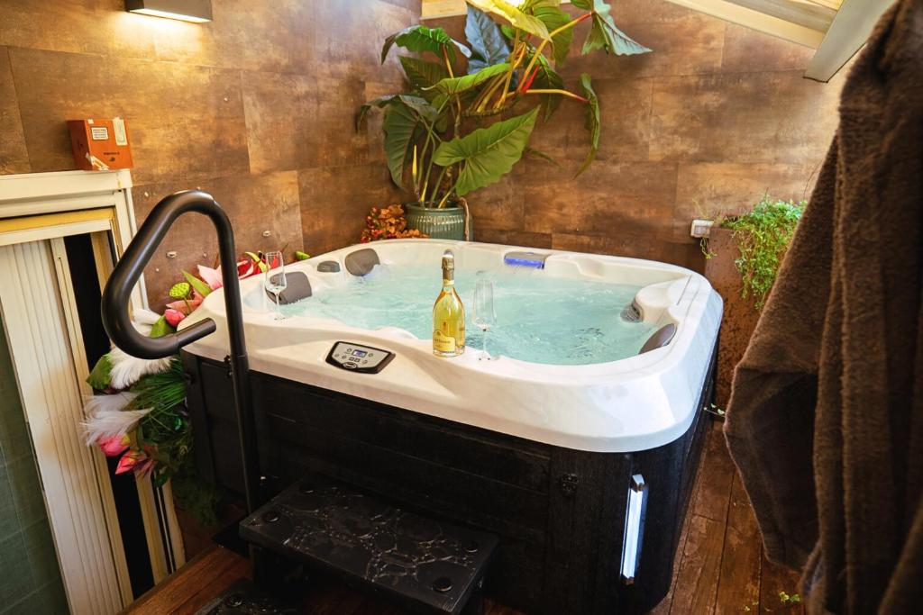 a bath tub with a bottle of champagne in it at Haven Loft Como - Private Spa, Parking & Jacuzzi in Como