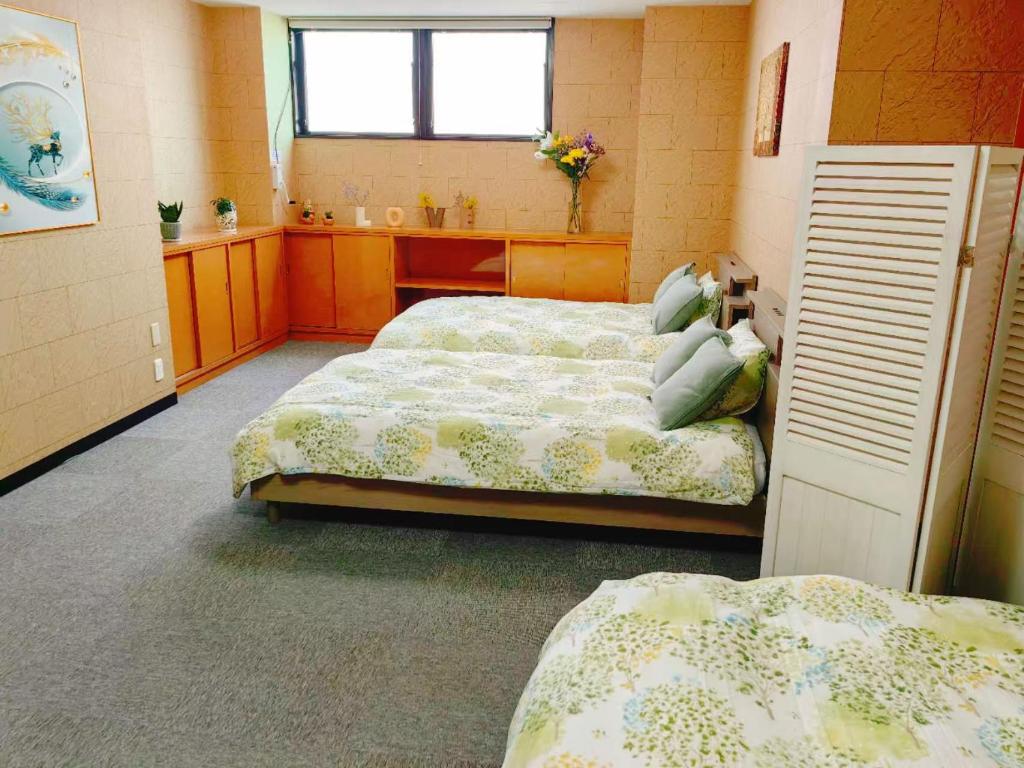 a bedroom with two beds and a sink at ゲストハウス瓦町 in Takamatsu