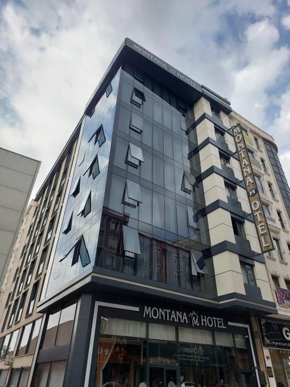 a tall building with a sign for a hotel at The Montana City Hotel in Bostaniçi