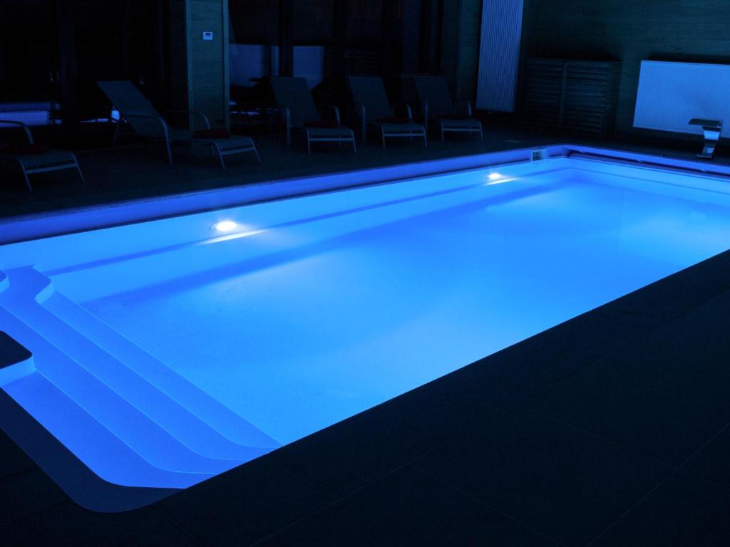 a swimming pool with blue lighting in a room at Luscious Holiday Home in Waimes with Pool Sauna in Robertville