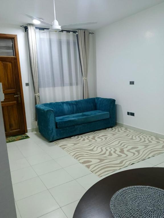 a blue couch in a living room with a rug at Bluu Diani in Diani Beach