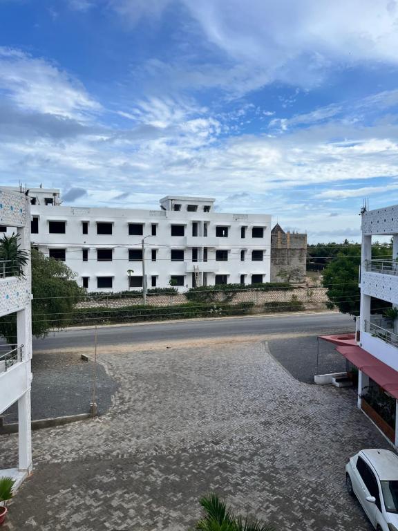 a large white building with a car parked in front of it at Azure Coast retreat in Watamu
