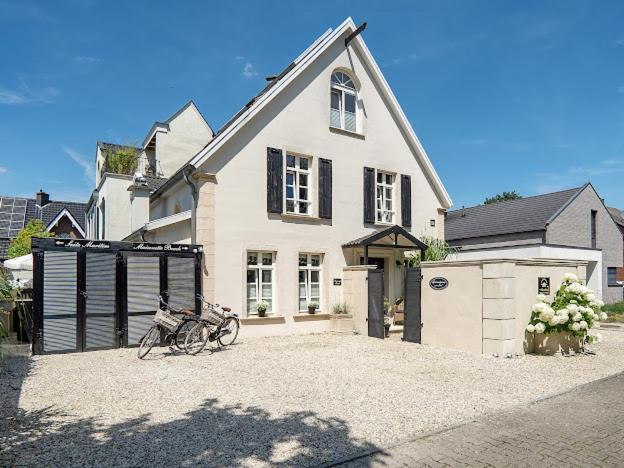 a white house with bikes parked in front of it at Ferienwohnung LA MAISON mit Sauna am See in Neuenkirchen