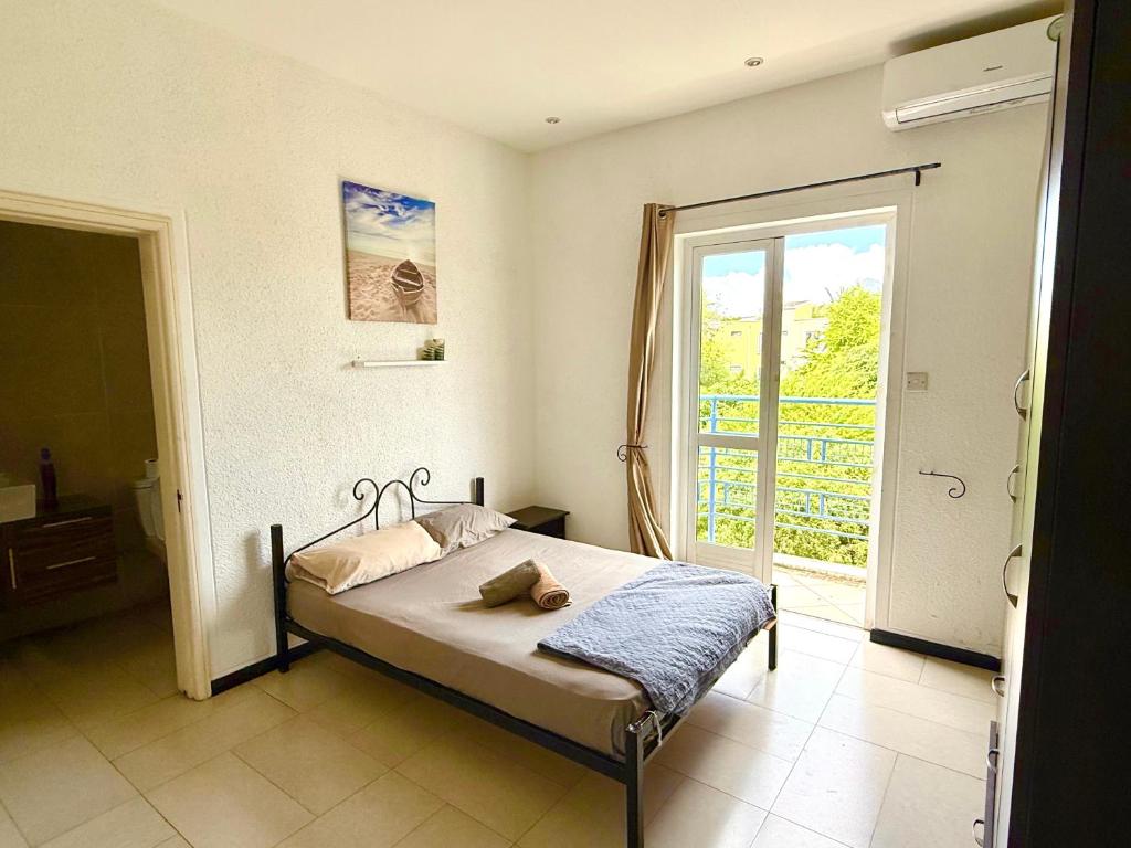 a bedroom with a bed and a large window at Ensuite Room in a shared apartment with pool in Albion