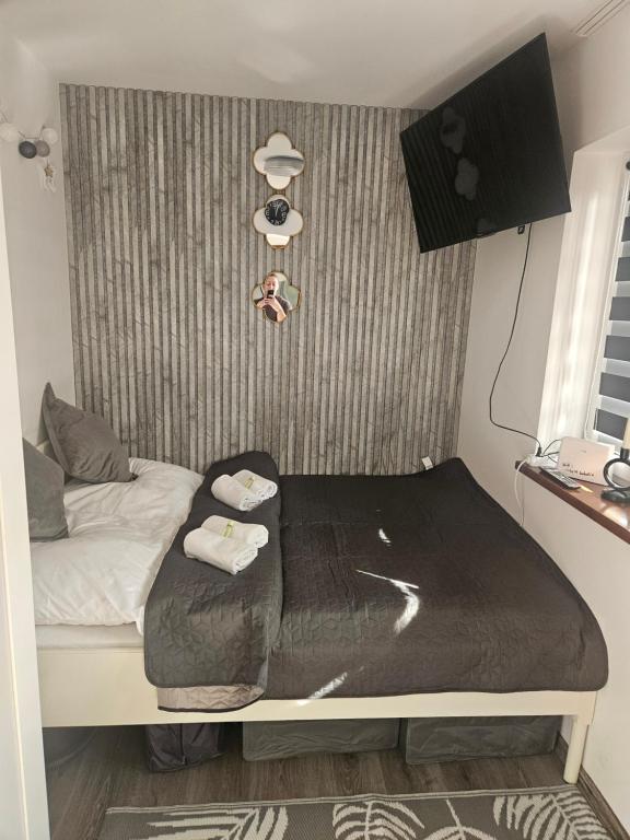 a small bedroom with a bed with a black blanket at Cichy Zakątek in Bobolin
